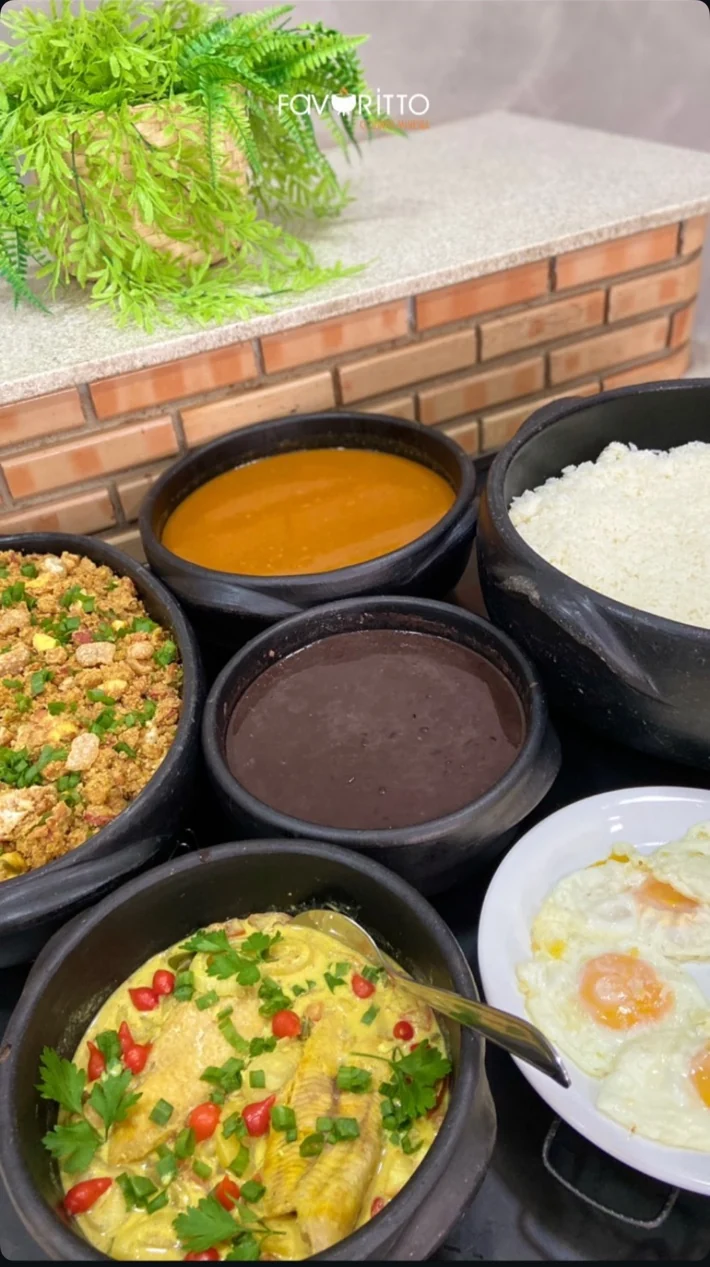 Panelas do buffet com arroz, feijão e preparações do Favoritto
